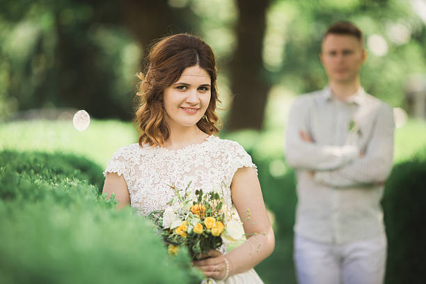 istock Bride posing and smiles while groom waits on the background 619728418