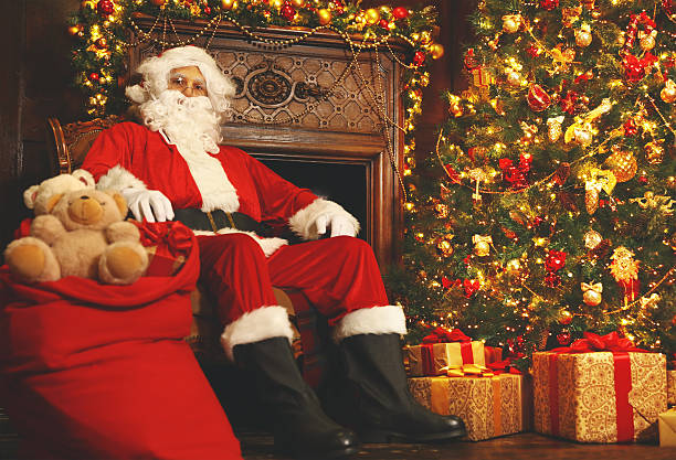 istock Santa Claus with gifts around Christmas tree 619729244