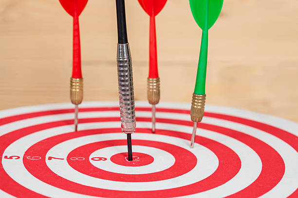 istock dart arrow and dartboard on wood background 619731950
