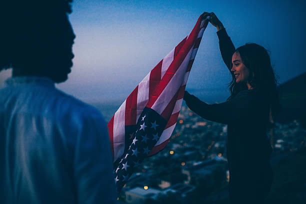 istock Friends waving USA flag at sunset 619732972