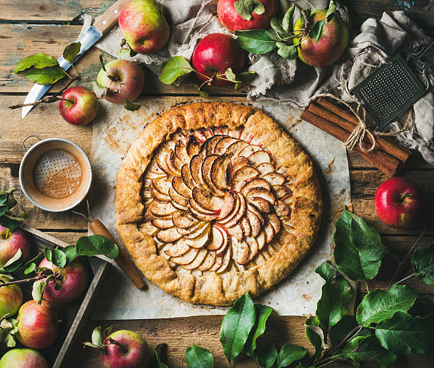 Apple crostata with cinnamon and fresh garden apples Apple crostata pie with cinnamon served with fresh garden apples with leaves on rustic wooden background, top view, horizontal composition crostata photos stock pictures, royalty-free photos & images
