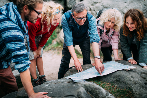 Group of Hikers checking route on map in the mountains