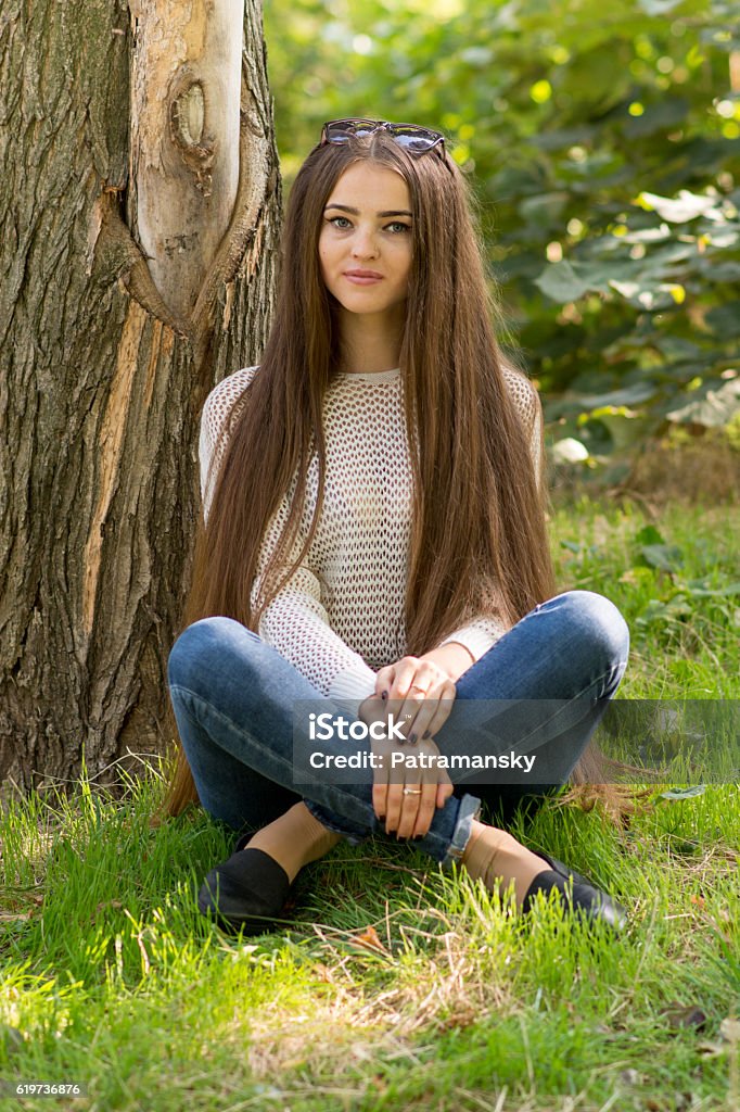 Woman With Long Hair In Jeans Sits In Lotus Pose Stock Photo - Download  Image Now - Adult, Affectionate, Autumn - iStock