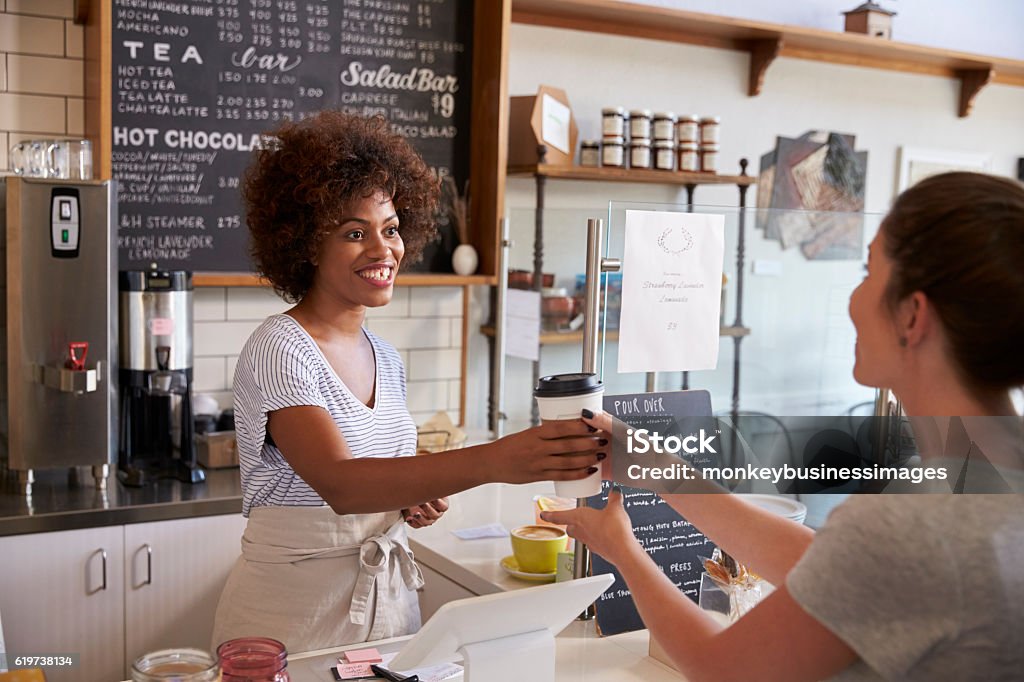 Kellnerin serviert Kunden über den Tresen in einem Café - Lizenzfrei Kaffee Stock-Foto
