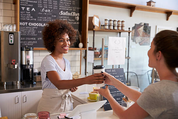 Waitress serving customer over the counter at a coffee shop