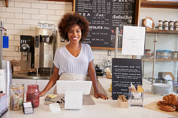 istock Smiling waitress behind counter at a coffee shop, close up 619738194