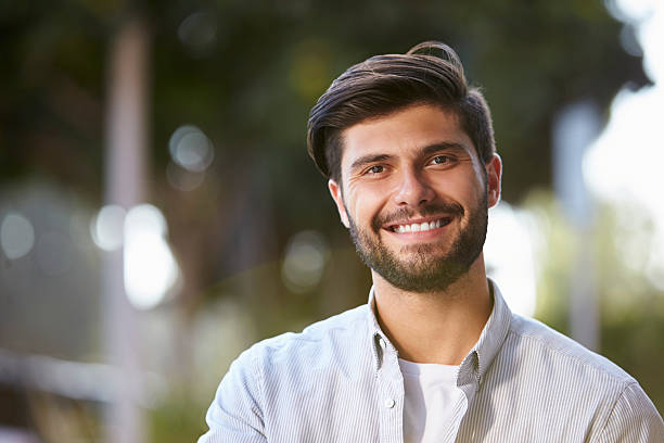 istock Smiling bearded young man sitting outside, portrait 619738310
