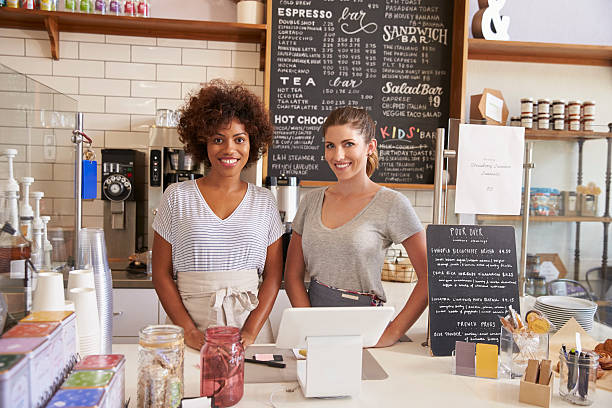 istock Two women ready to serve behind the counter at a coffee 619738370