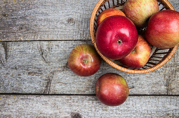 istock Apples in basket on rustic wooden background 619738886