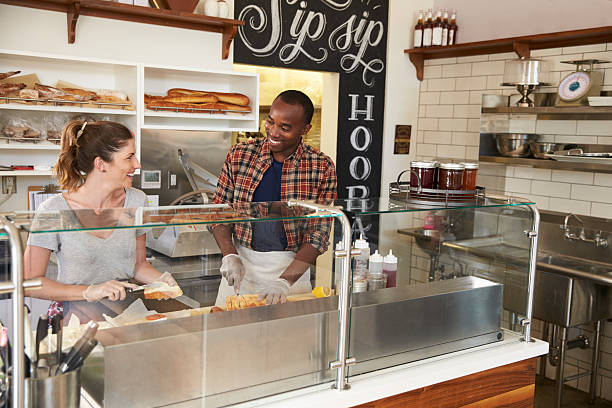 istock Mixed race couple working behind counter at a sandwich bar 619738964