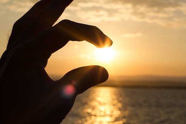 istock Hand and sunset on the sea 619740252