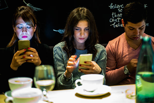 istock Boy and his friends sitting in cafe and using smartphones 619740640