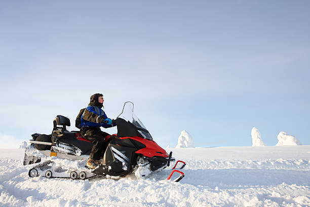 istock Man driving snowmobile in Finland 619745336