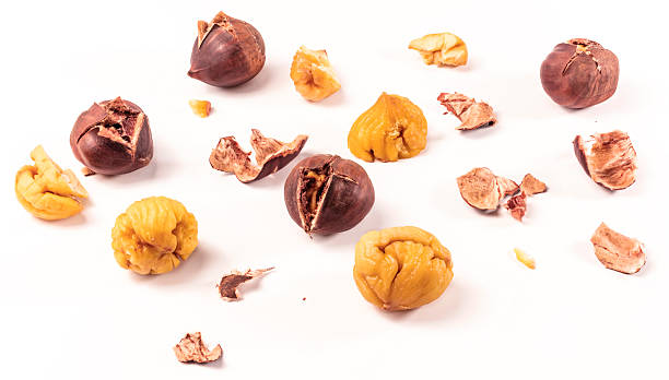 istock Peeled and unpeeled roasted chestnuts on white background 619745468