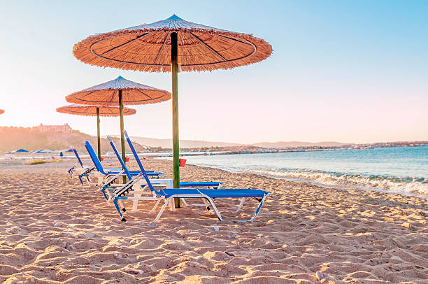 istock Three blue sunbed, straw umbrella on beautiful beach background 619745802