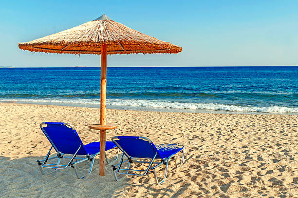 istock Two blue sunbed, straw umbrella on beautiful beach background 619746794