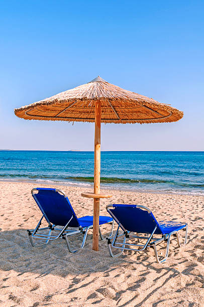 istock Two blue sunbed, straw umbrella on beautiful beach in Tripiti 619747146