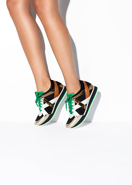 Woman's legs in sneakers Woman's legs in sneakers on isolated white background ( with clipping path) brown leg stock pictures, royalty-free photos & images