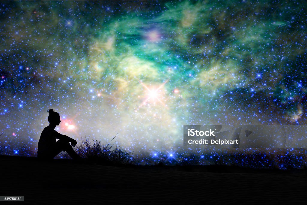 Silhouette of a woman sitting outside, starry night background Silhouette of a woman sitting outside, starry night background - NASA elements are included Women Stock Photo