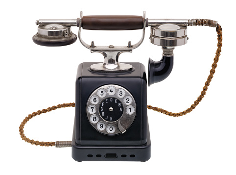 Isolated objects: one antique black telephone, very old and aged, isolated on white background