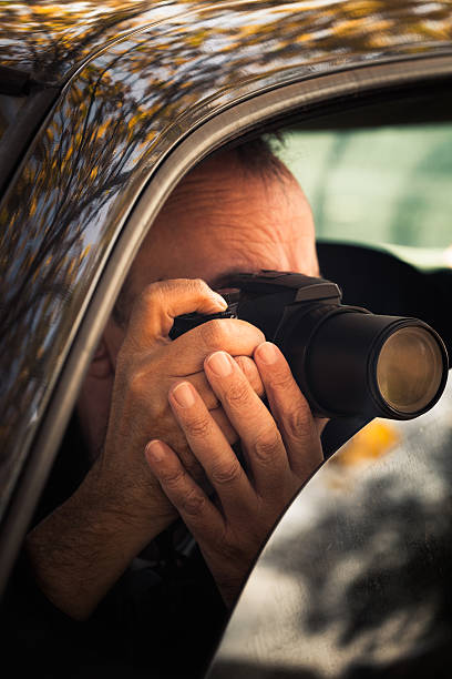 istock undercover man hidden in car take photo 619753250