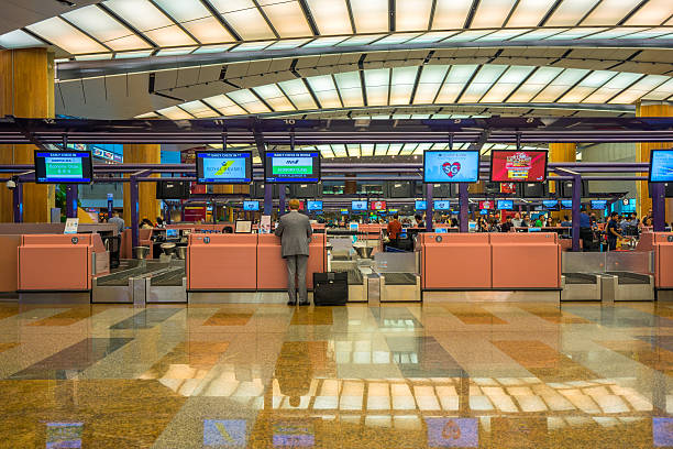 hall de départ à l’aéroport de changi avec zone d’enregistrement - airport arrival departure board airport check in counter airplane photos et images de collection