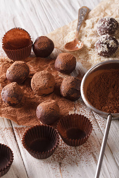 istock sprinkling chocolate truffles cocoa powder and nuts close-up 619755366