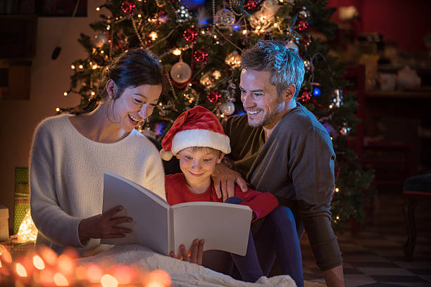 istock Christmas night. a nice family reading a book together 619755580