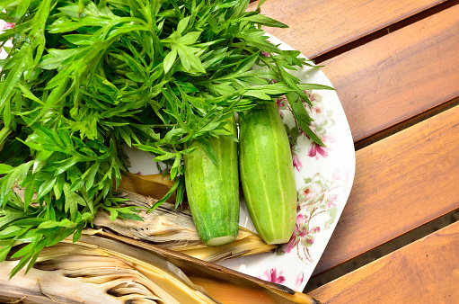 Malay traditional food. Cosmos caudatus with edible banana flower and cucumber on wooden board