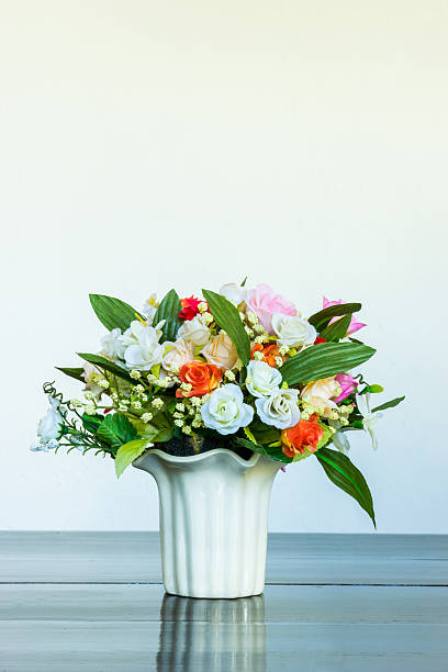 istock Vase of artificial rose on wooden bench 619756342