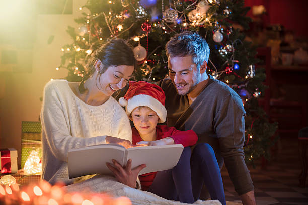 istock Christmas night. a nice family reading a book together 619756414