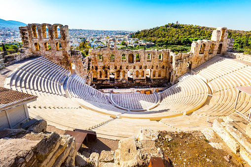 Follow me to Acropolis in Athens, Greece. Smiling female tourist leading boyfriend to the magnificent famous Parthenon. People travel concept