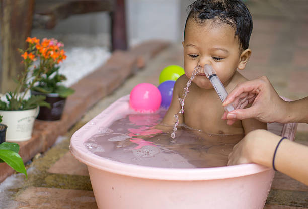 lavagem nasal de bebê asiático - child human nose allergy spraying - fotografias e filmes do acervo