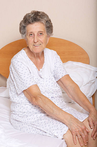 istock Senior woman is sitting in her bed 619759238