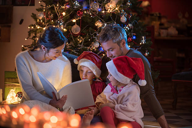 istock Christmas night. a nice family reading a book together 619759494