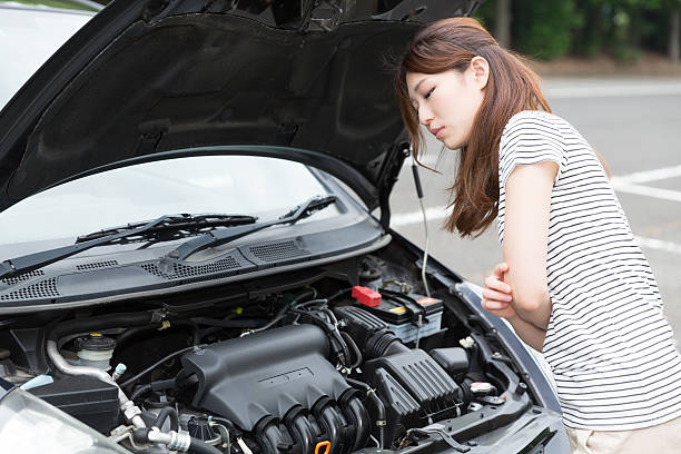 istock Woman standing next to open car bonnet 619759952