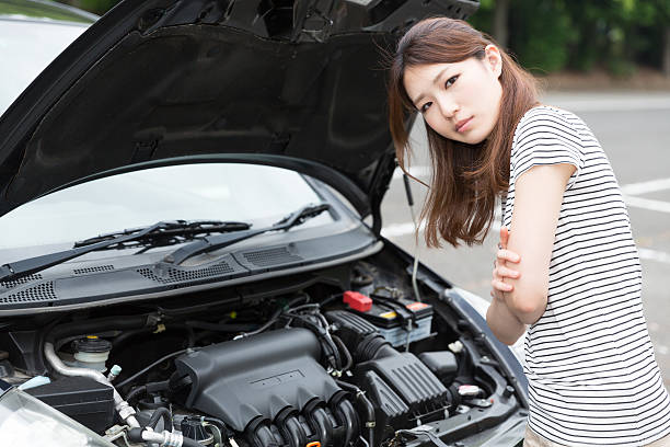 istock Woman standing next to open car bonnet 619760018