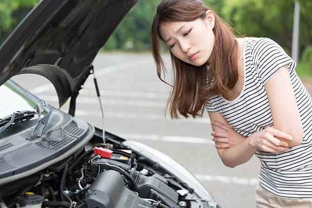 Woman standing next to open car bonnet