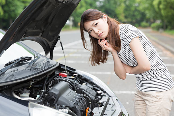 istock Woman standing next to open car bonnet 619760126