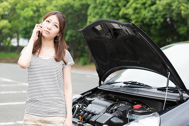 istock Woman standing next to open car bonnet 619760456