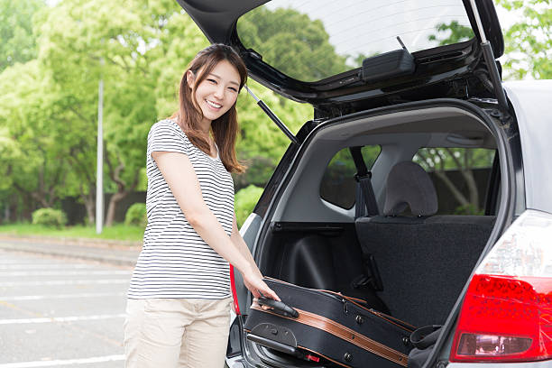 istock Woman standing next to a car boot 619760648