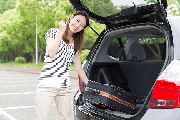 istock Woman standing next to a car boot 619760754