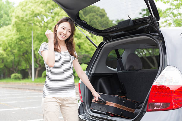 istock Woman standing next to a car boot 619760824