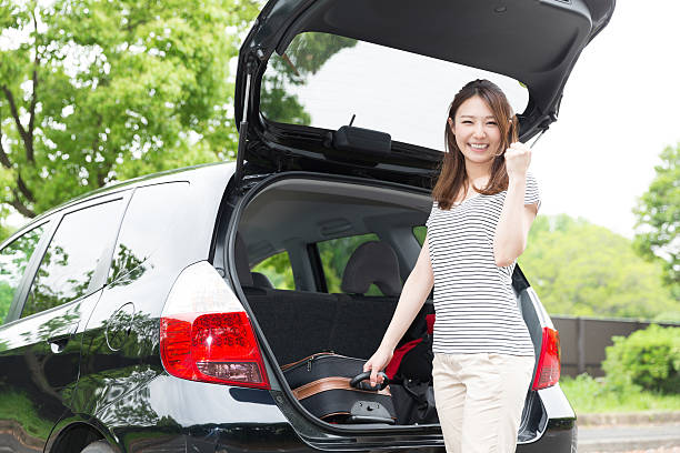 istock Woman standing next to a car boot 619760864