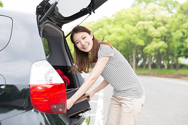 istock Woman standing next to a car boot 619761022