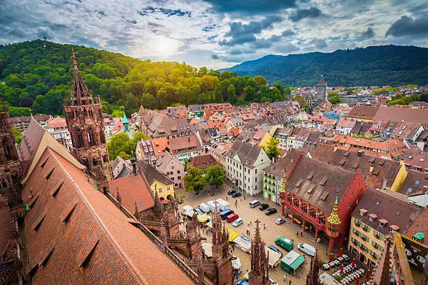 Aerial view of the historic city center of Freiburg im Breisgau from famous Freiburger Minster in beautiful evening light at sunset with blue sky and clouds in summer, Baden-Wurttemberg, Germany.