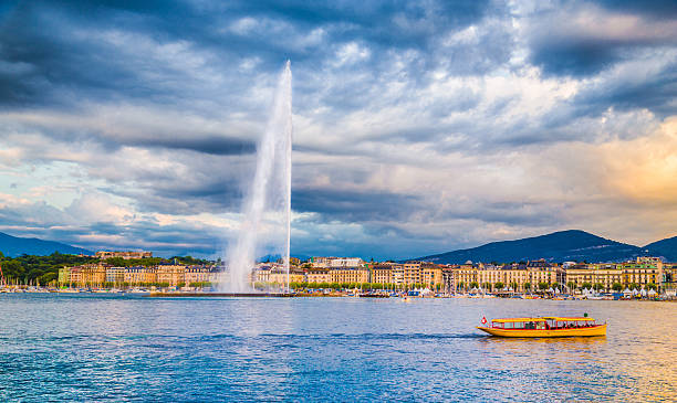 City of Geneva with Jet d'Eau fountain at sunset, Switzerland Panoramic view of historic Geneva skyline with famous Jet d'Eau fountain at harbor district in beautiful evening light at sunset with blue sky and clouds in summer, Canton of Geneva, Switzerland geneva switzerland photos stock pictures, royalty-free photos & images