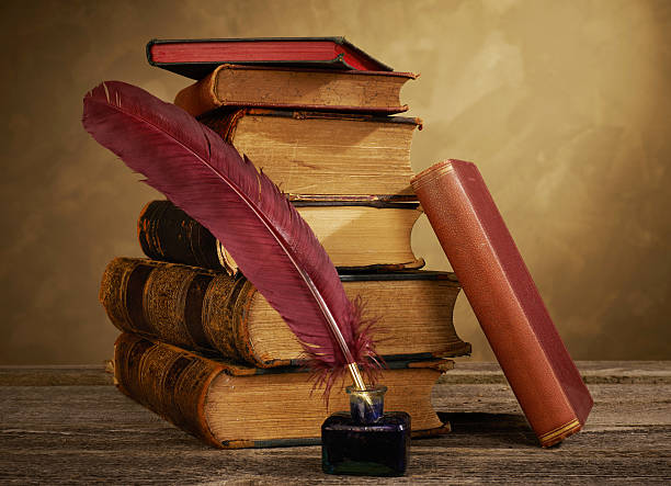 istock Ink pot, quill and antique books 619768250