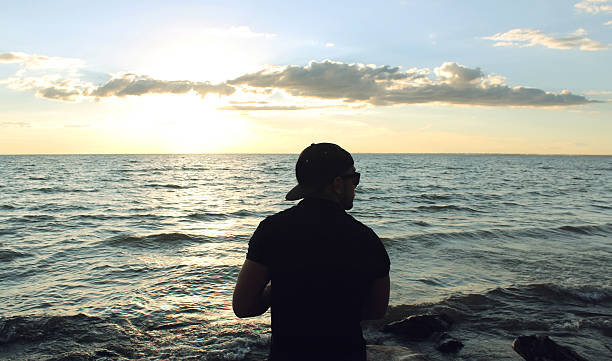 istock Man looks at sea at the sunset 619768608