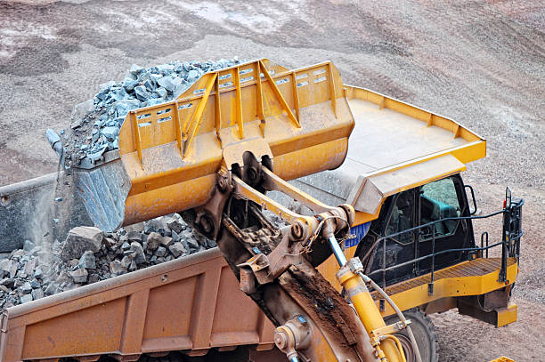 istock earthmover loading a dumper truck with stone material 619768892